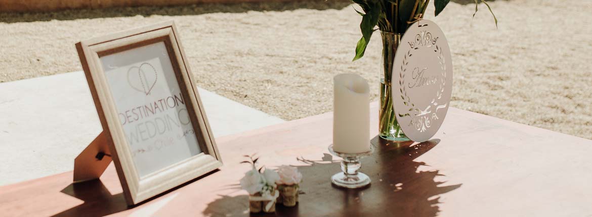 table decorated with flower arrangement, candle and a writing board destination wedding chile