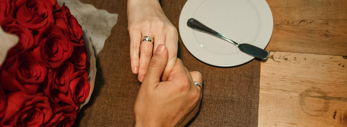 Mãos do casal com as alianças de noivado